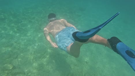a tourist snorkeling going underwater