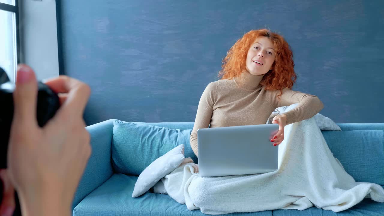 Woman Taking Photo Shoot on Sofa While Using Laptop