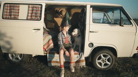 woman and dog posing in travel trailer during golden hour