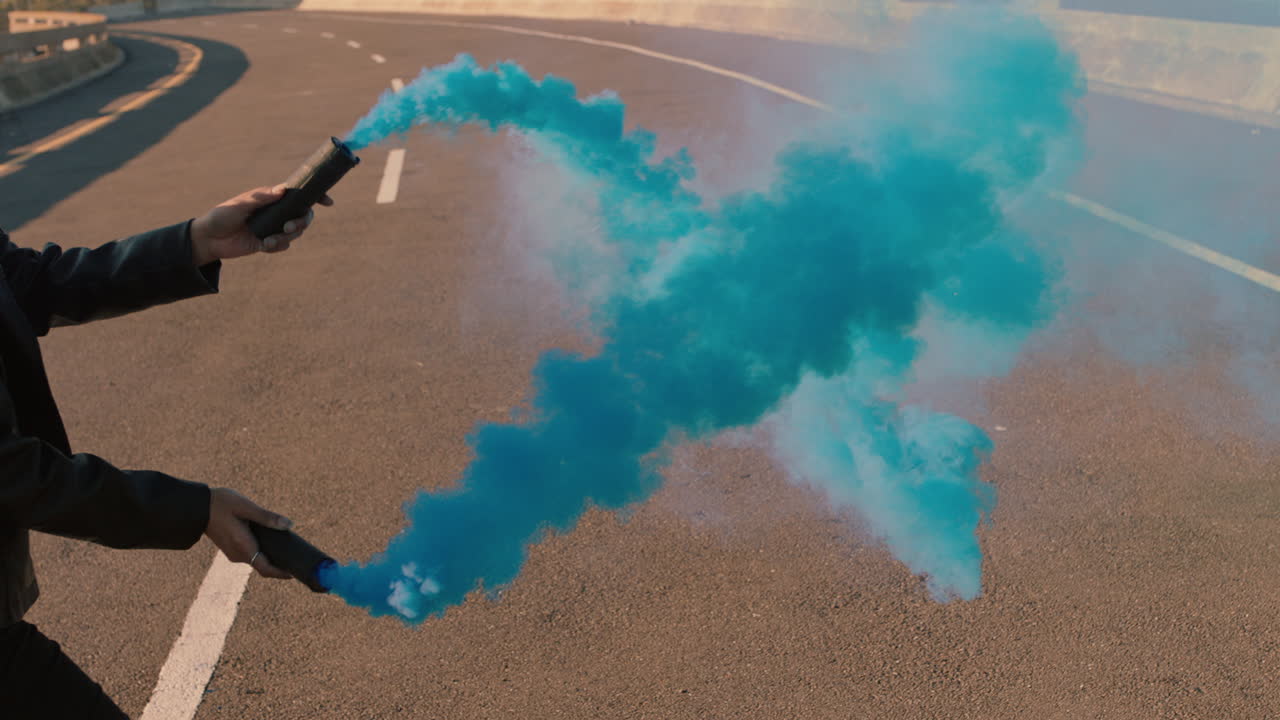 도시 거리에서 파란색 연기 폭탄을 흔들고 춤을 추는 여성  ⁇ 합 댄서 소녀가 춤의 느린 움직임으로 창조적 인 자유를 축하합니다.