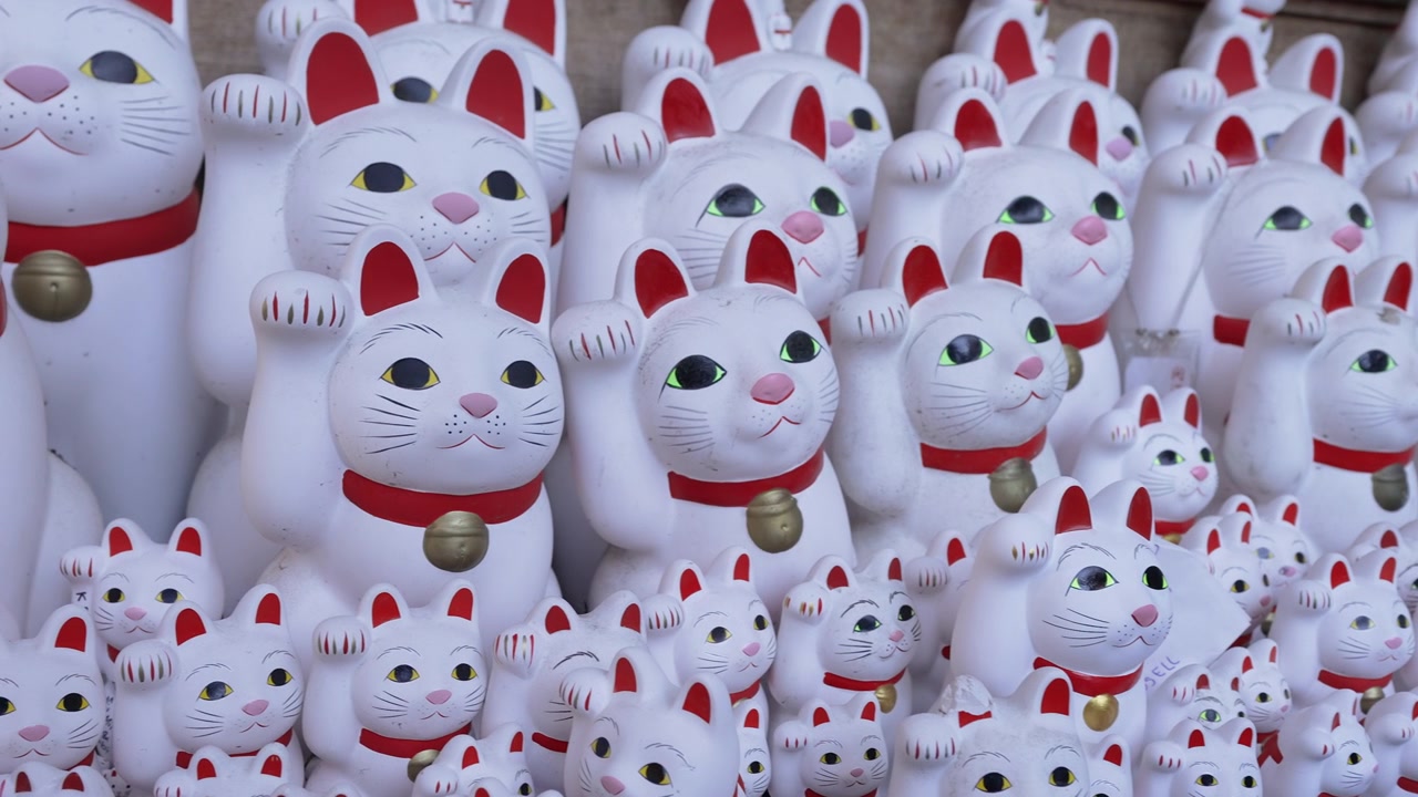 Tapınak raflarında sonsuz sıralar halinde dizilmiş beyaz Maneki-neko şans kedileri.
