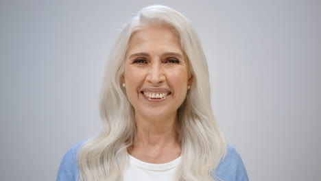 Cheerful-elderly-woman-laughing-inside.-Senior-lady-spending-time-in-studio.