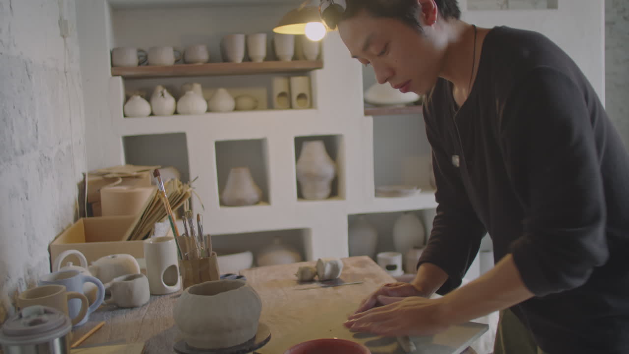 Asian Ceramist Rolling Clay Coil in Pottery Workshop