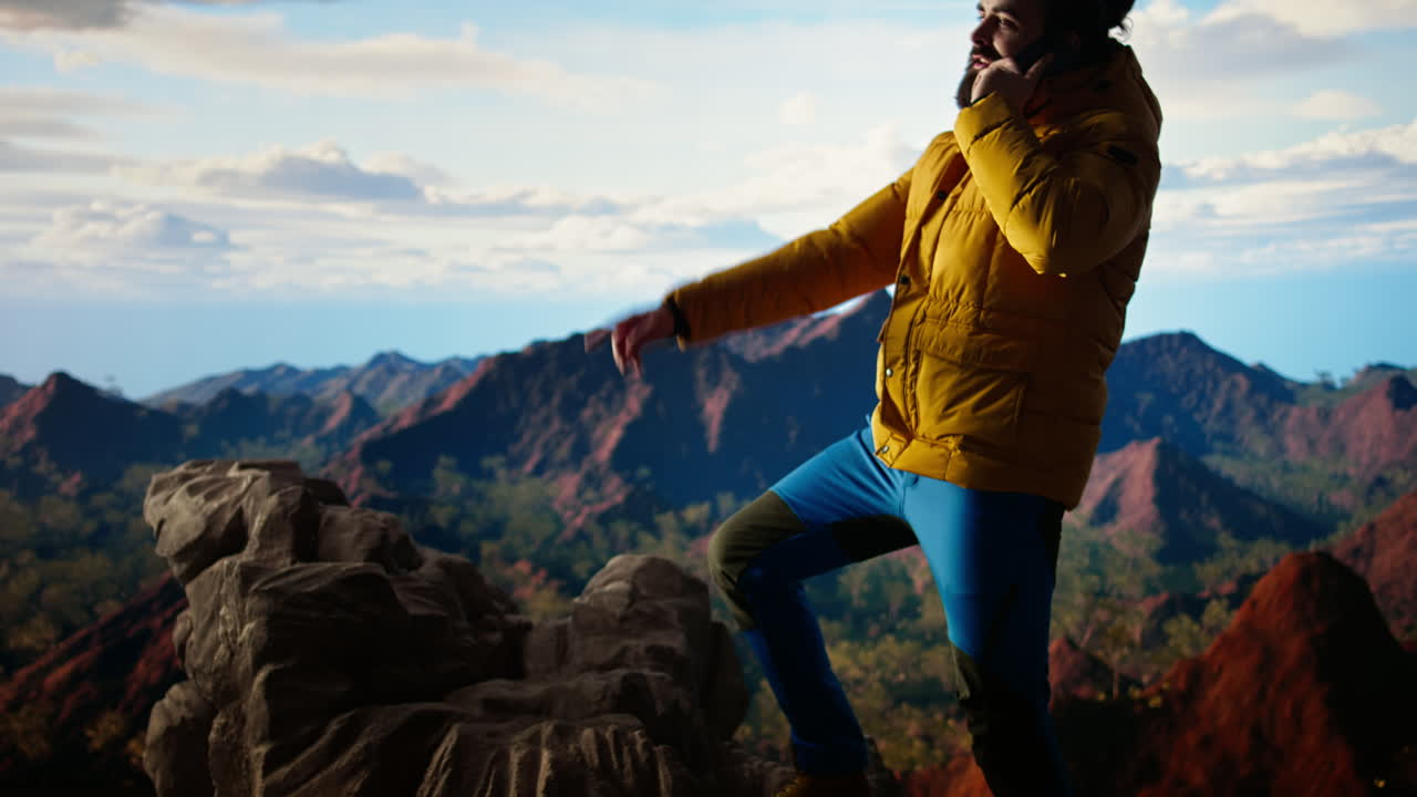 el excursionista disfruta del paisaje de gran altitud y hace una llamada telefónica