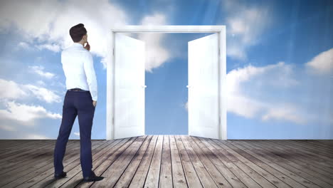 la puerta se abre al cielo azul observado por el hombre de negocios