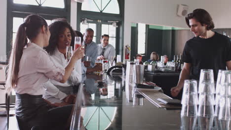 two businesswomen meeting for after works drinks in bar