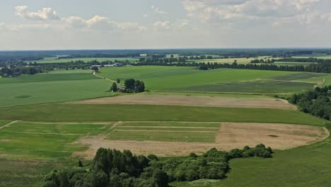 forward moving aerial of fields and a farmhouse in summer