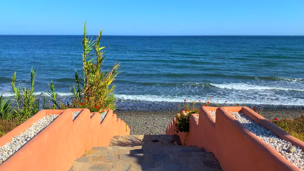 hermosas escaleras al océano, escalones que conducen al mar en marbella estepona, españa, tiro estático de 4k