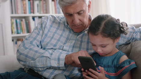 happy-grandfather-showing-little-girl-how-to-use-smartphone-teaching-curious-granddaughter-modern-technology-intelligent-child-learning-mobile-phone-sitting-with-grandpa-on-sofa