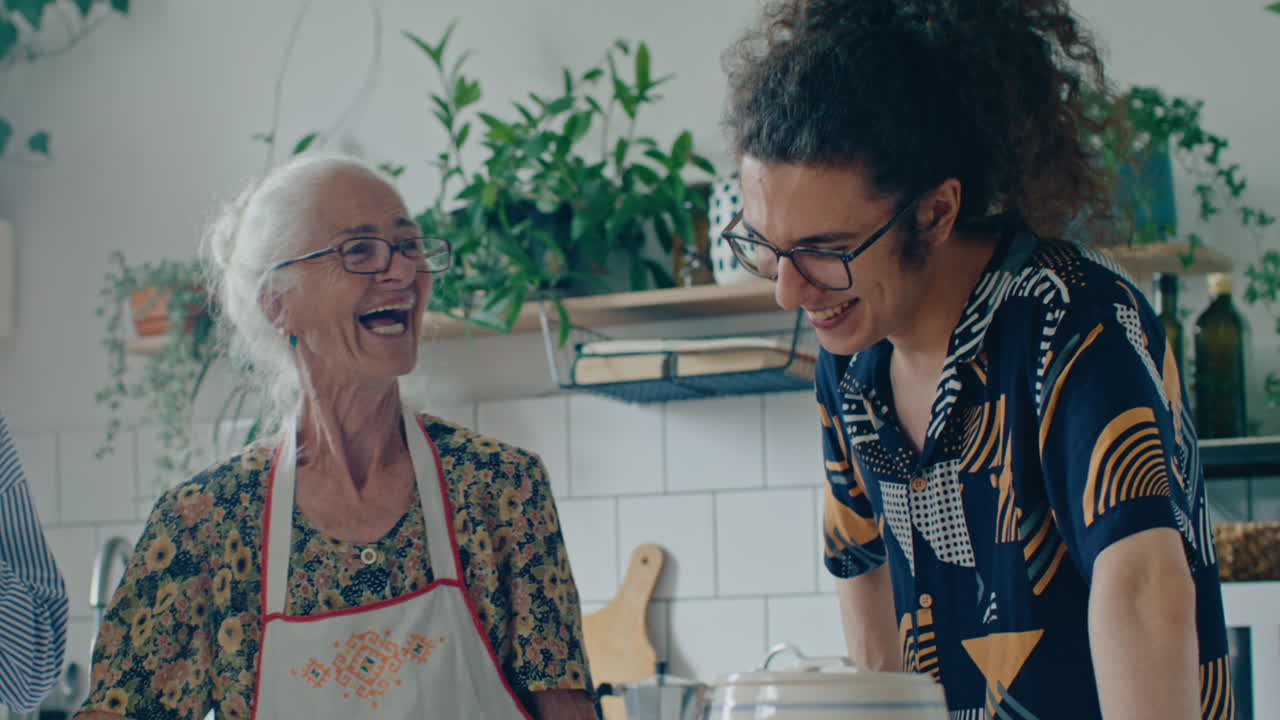 Giovane che ride e chiacchiera con la nonna nella cucina di casa