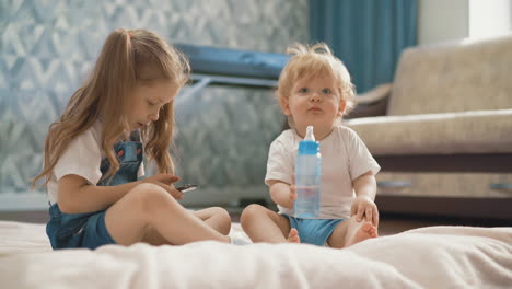 los niños se sientan en el suelo, la niña juega.