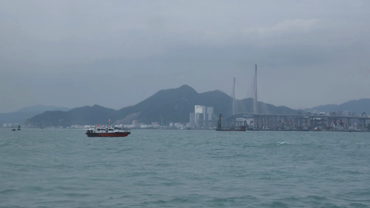 View from over the water of small boat and Hong Kong hills