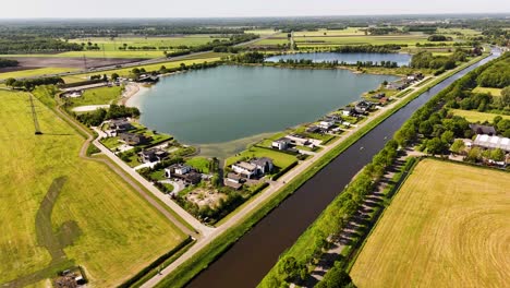 aerial view of modern houses surrounding a lake and canal in a dutch countryside