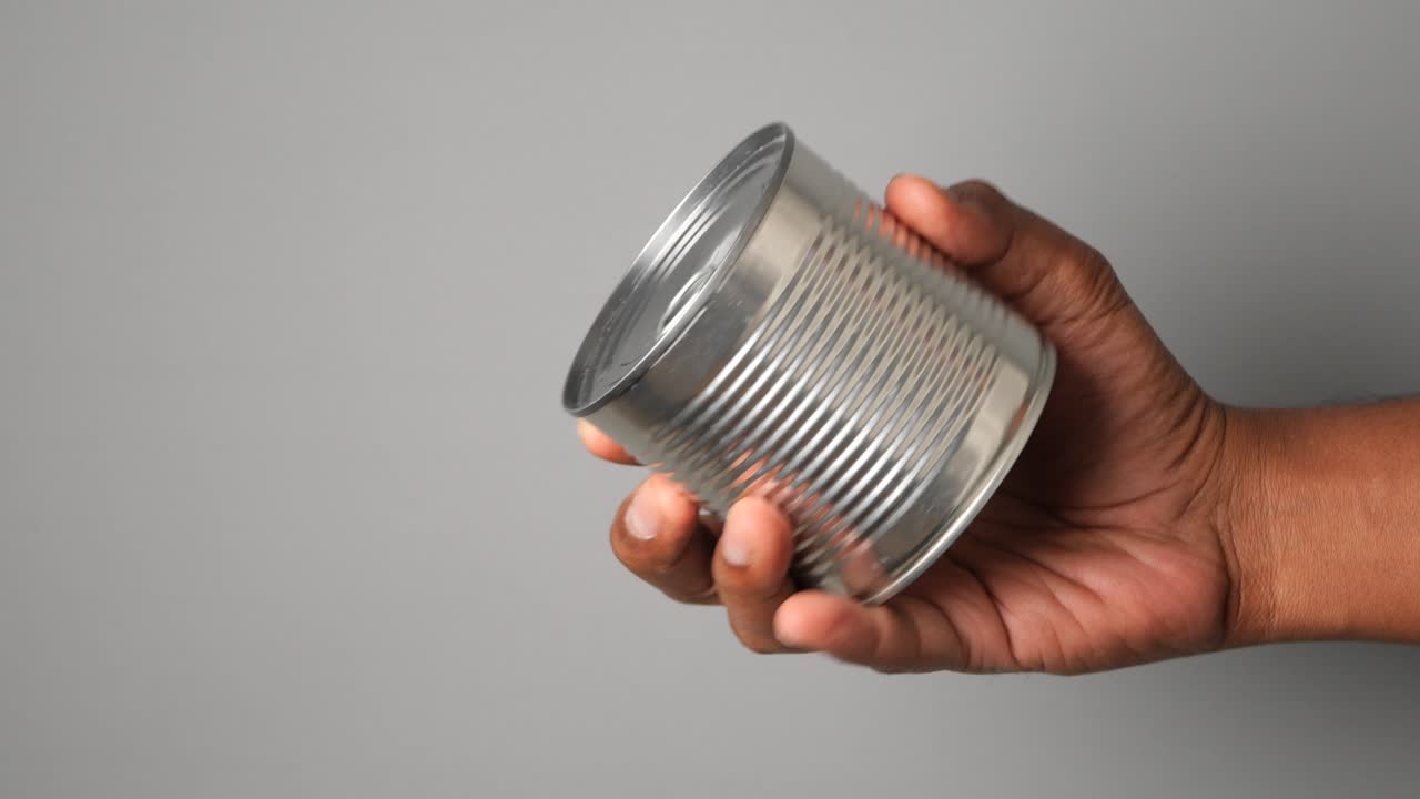 Hand holding a tin can