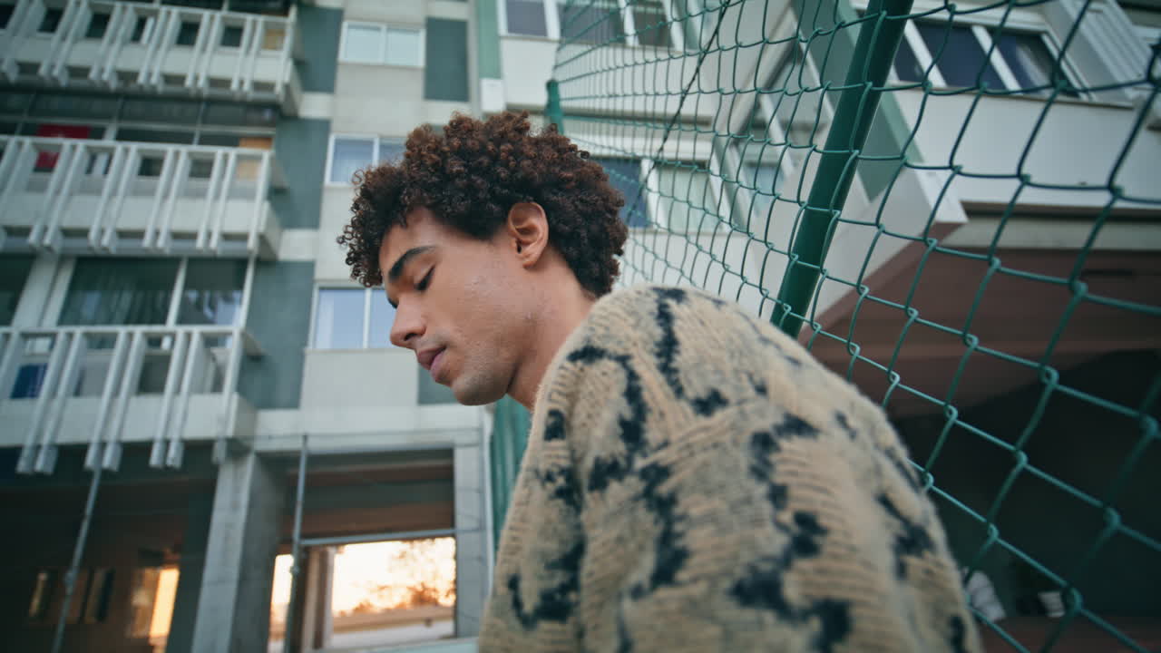 Serious guy leaning urban fence closeup. Metropolitan man standing town district
