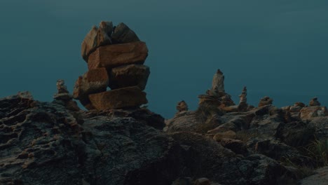 stone cairn on rocky coastline at sunrise/sunset