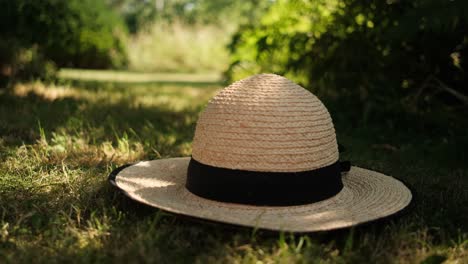 Sommerstrohhut-Auf-Dem-Gras-Im-Schatten-Des-Baumes-Platziert