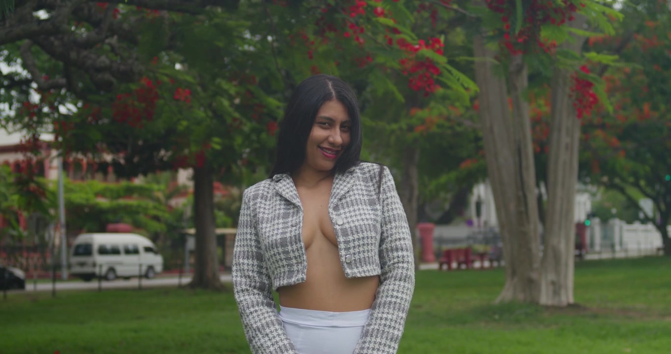 A stylish Latina young woman wearing a jacket and mini skirt takes a relaxed stroll through downtown on a sunny afternoon.