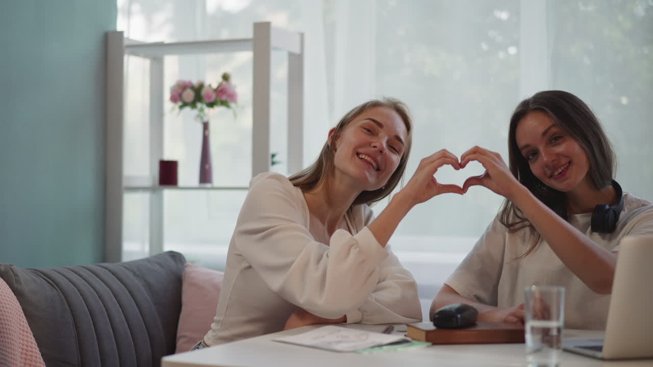 레즈비언 부부는 사랑을 표현하는 손으로 심장 모양을 만 ⁇ 니다.