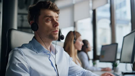 thoughtful agent talking headset with client closeup. professional support agent