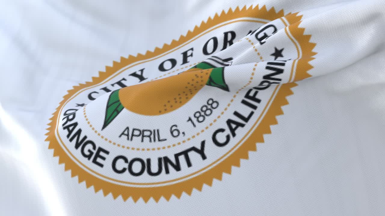 Bandiera della città di Orange, California, Stati Uniti, che sventola lentamente al vento. In loop