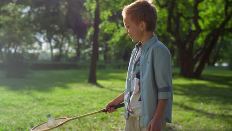 Der-Lächelnde,-Fröhliche-Junge-Legte-Den-Federball-Auf-Den-Schläger.-Kinder-Spielen-An-Einem-Sonnigen-Tag-Badminton.