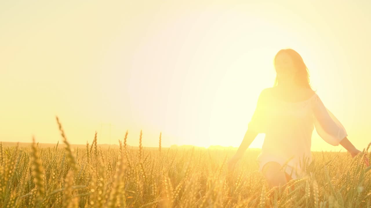 mujer en un campo de trigo al atardecer