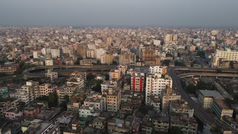 Smoggy-skyline-of-Dhaka-with-traffic-on-highway,-aerial-view-of-densely-built-city