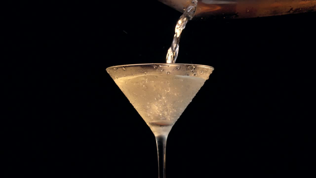 Un dirty Martini viene versato in un bicchiere da Martini freddo