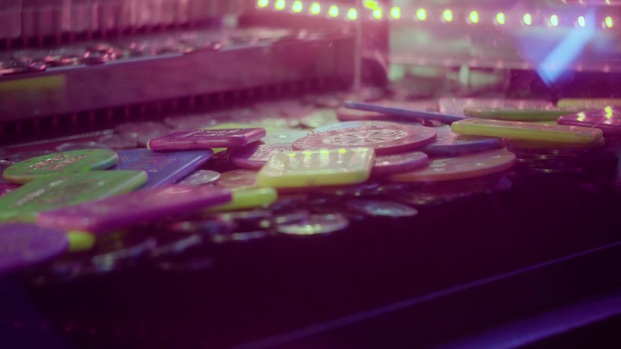 Primo piano di un gioco a gettoni in un luna park con il riflesso della luce sulla vetrina