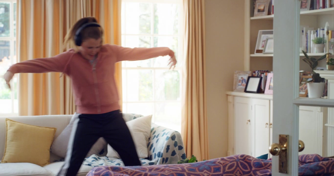 Young Woman Dancing on Sofa at Home