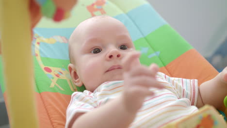 pequeña cara de bebé. primer plano de un bebé lindo acostado en una alfombra colorida