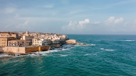 aerial hyperlapse along the coast of ortigia island in sicily. medieval town by the mediterranean sea. unesco world heritage site in italy.