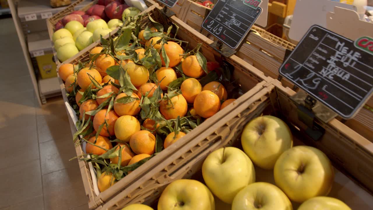 Fresh oranges an apple in local market on display, moving over shot
