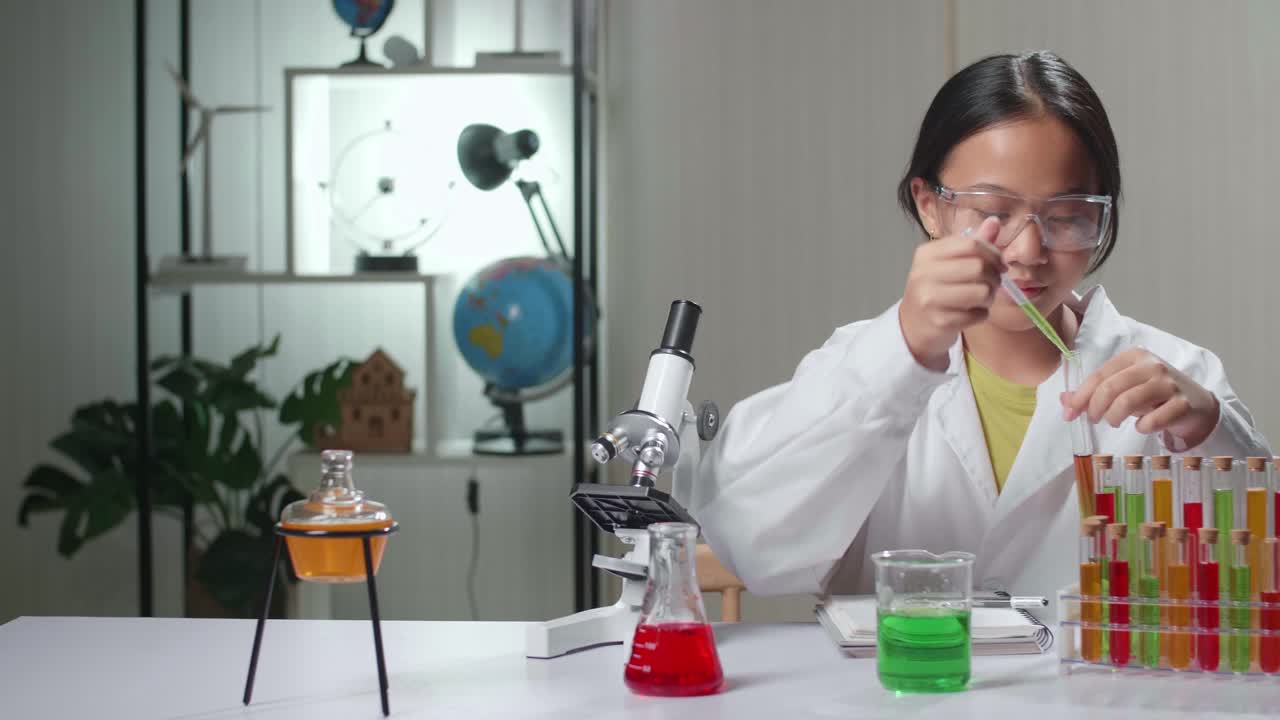Young Asian Scientist Girl Mixes Chemicals In Test Tube And Note On Her Book. Child Learn With Interest