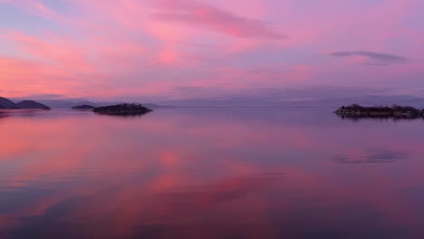 Atemberaubende-Landschaftsaufnahme-Von-Orangefarbenem-Und-Violettem-Sonnenuntergang,-Der-Sich-Im-See-Widerspiegelt