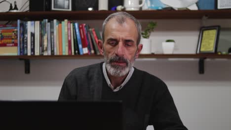hombre maduro trabaja desde casa con su laptop
