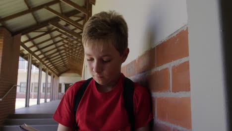 boy reading books in the school corridor