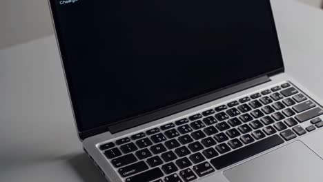 a sleek laptop on a round table, captured from a high-angle view, suggesting a modern workspace