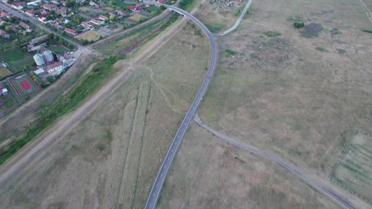 volando por encima de la aldea remota y rural con la conducción de automóviles