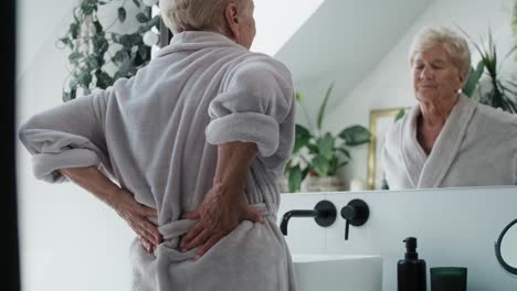 senior caucasian woman in the bathroom having a strong backache