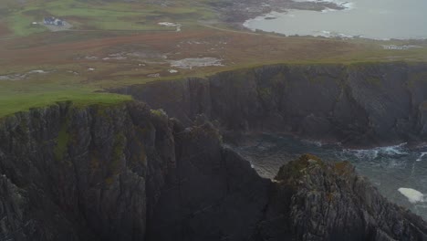 aerial pull-back reveals rugged malin head coastline shrouded in fog.