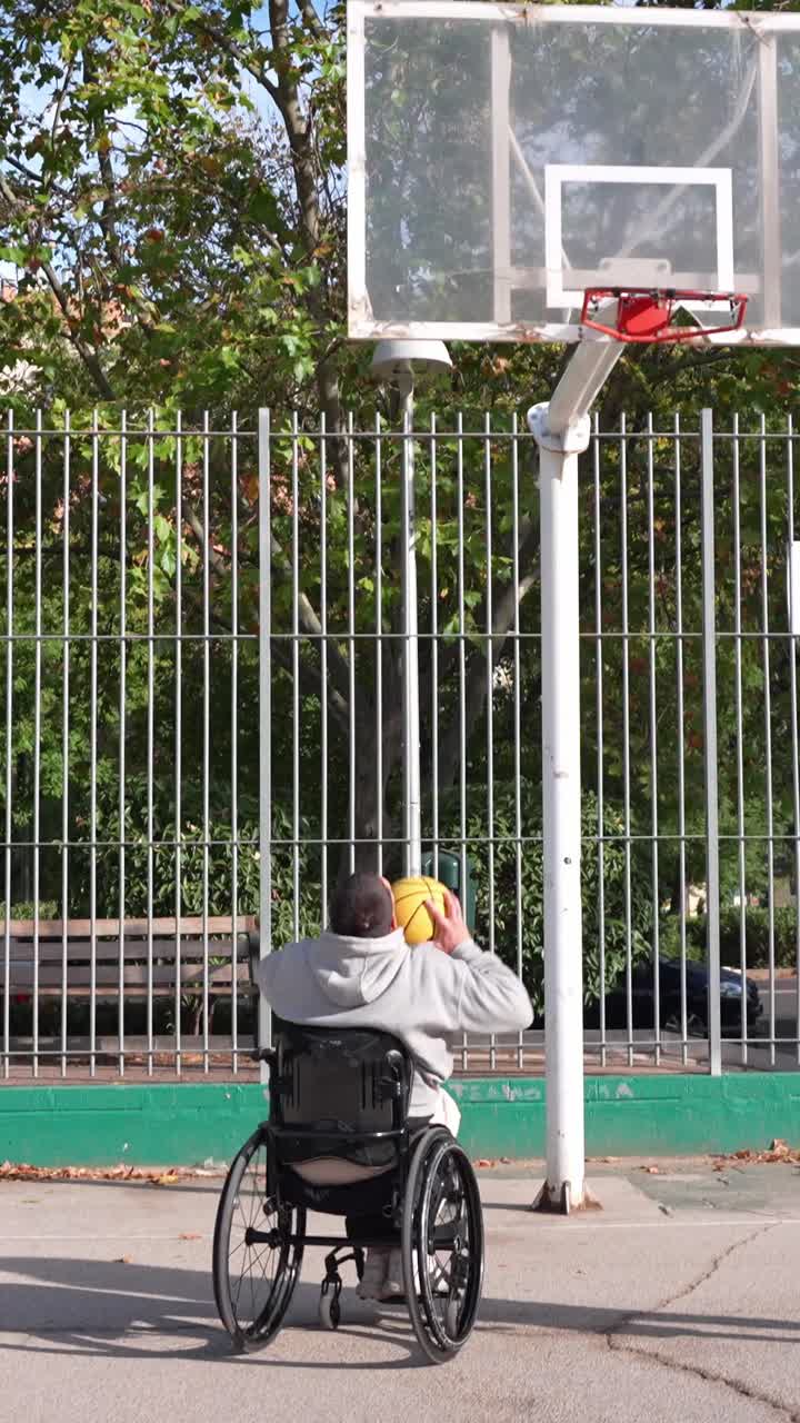 Young Man in Wheelchair Playing Basketball with Friend on Court