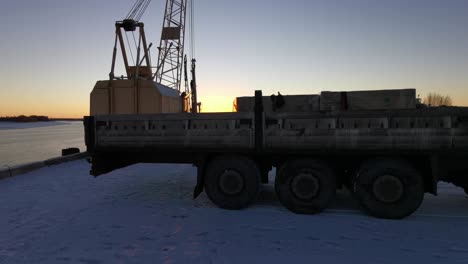 truck with cargo at a dock during sunrise/sunset, winter season