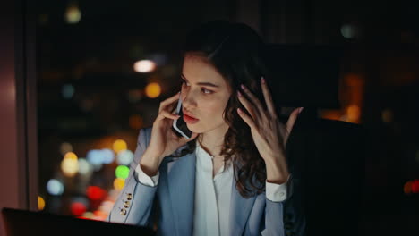 worried business lady calling clients at workplace in night close up. tired girl