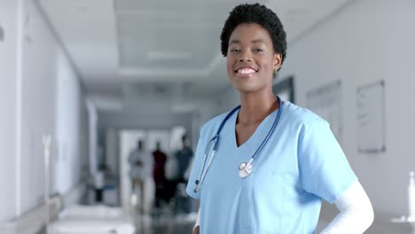 african american female doctor smiling in hospital corridor, slow motion