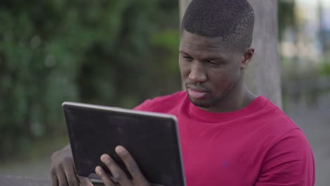 sad man watching football match on tablet, massaging head