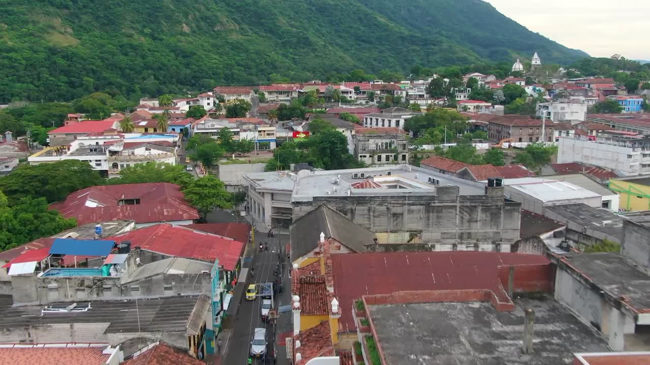 vuelo aéreo a través de las torres de la catedral sobre la bulliciosa ciudad de américa central por las montañas