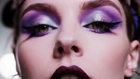 close-up portrait of a woman with vibrant purple makeup
