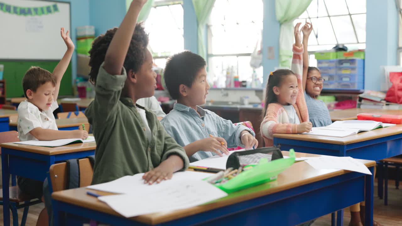 Students in a classroom raising their hands